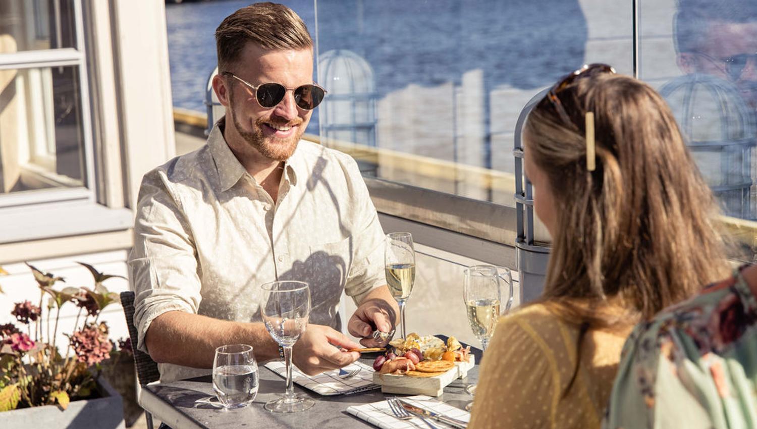 et par på utesrestaurnat i sjøkanten på Clarion Hotel Tyholmen