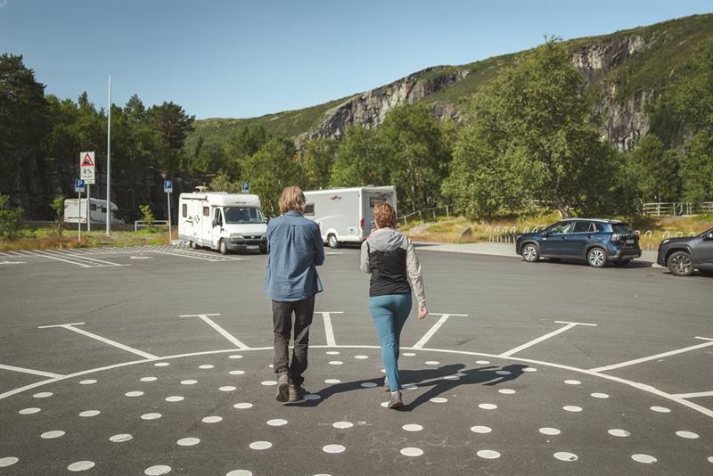 A couple walking from the Fossatromma parking area towards the path down the old Måbø road.