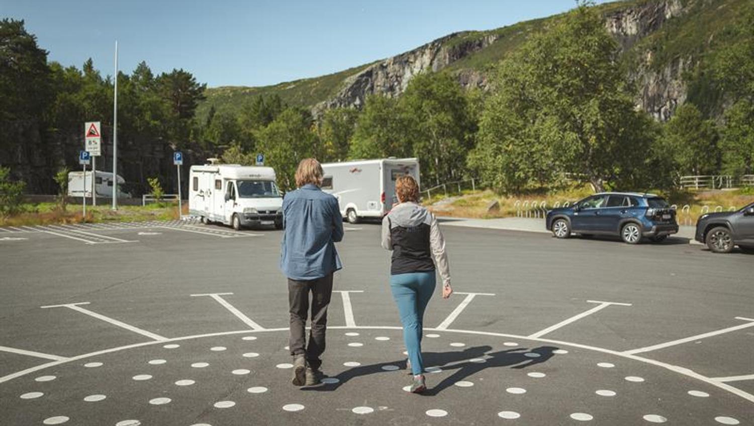 A couple walking from the Fossatromma parking area towards the path down the old Måbø road.