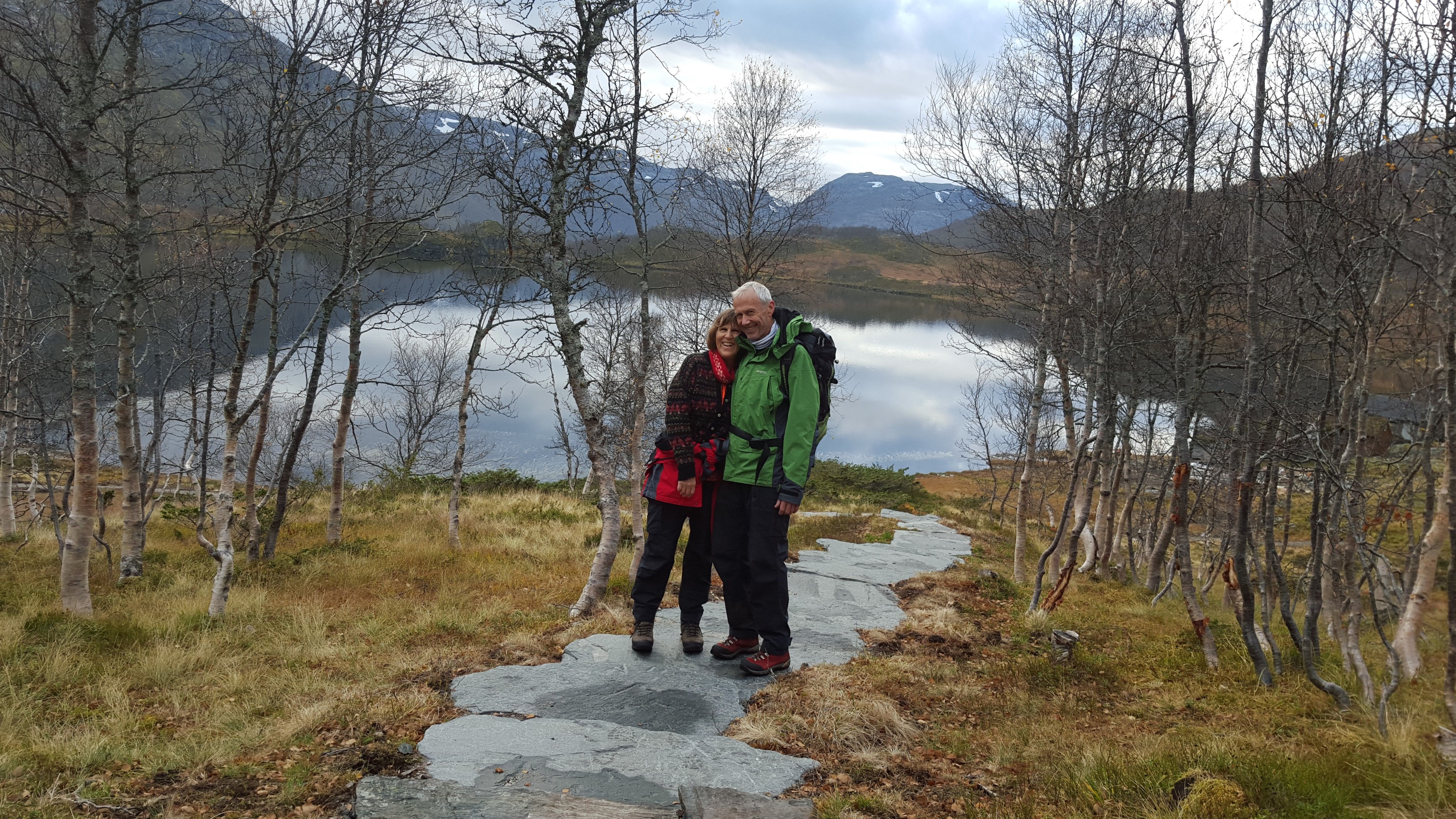 a couple posing for a photo by the mountain lake 