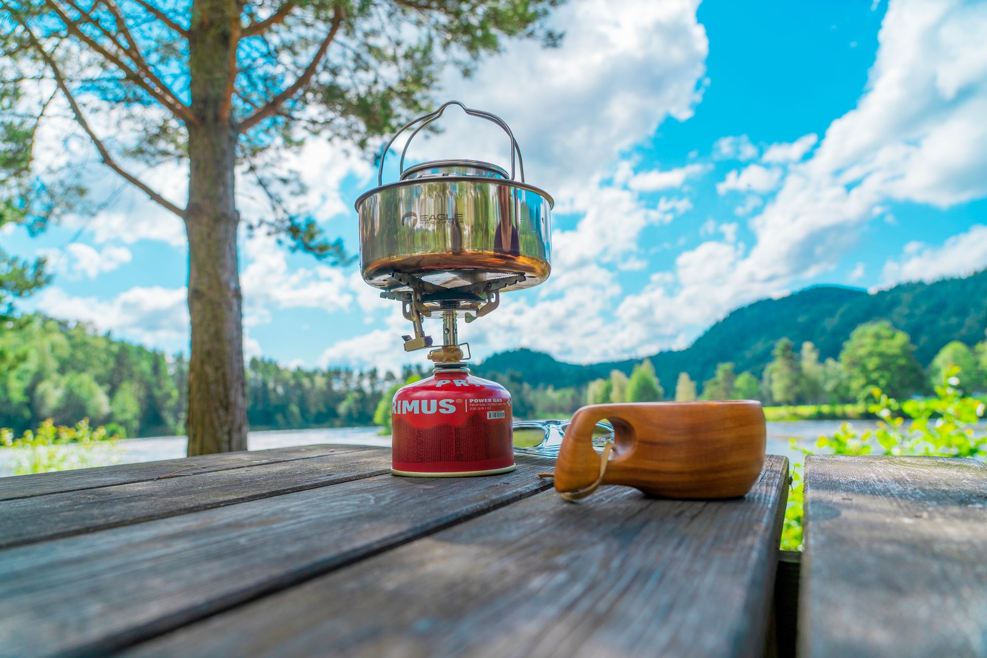 A coffee cup and a camping stove on a table outdoors at Villmarkscamp
