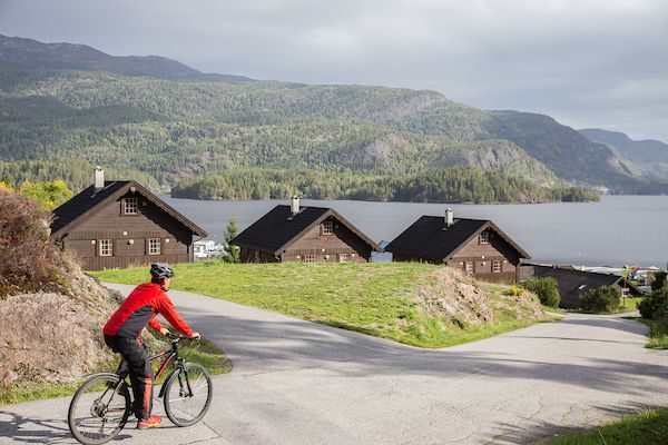 The cyclist rides past cabins.