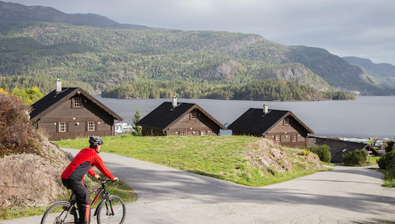The cyclist rides past cabins.