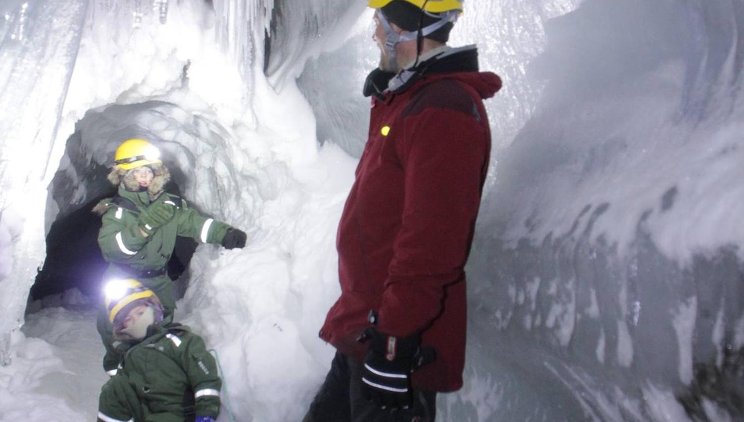 A guide and two children inside the ice cave
