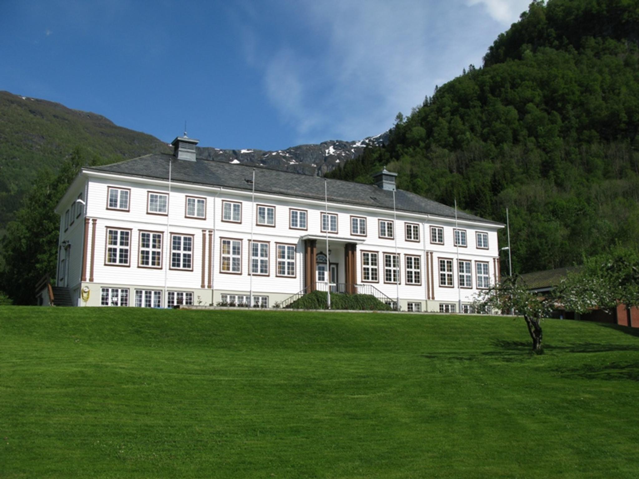 Hardanger Hostel B&B – charming white guesthouse surrounded by lush hills and mountains in Hardanger, Norway.