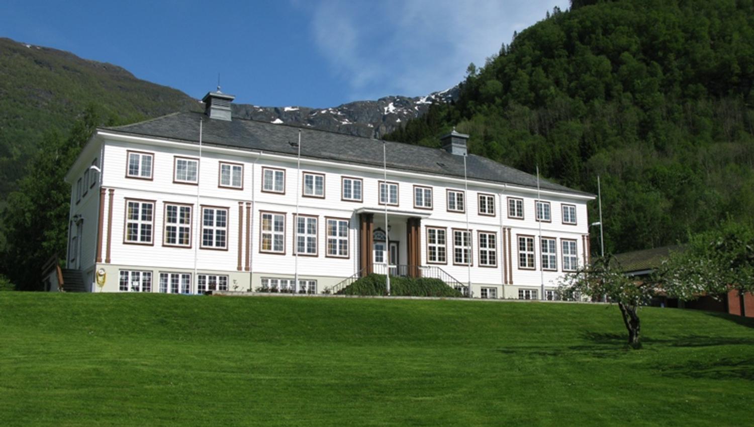 Hardanger Hostel B&B – charming white guesthouse surrounded by lush hills and mountains in Hardanger, Norway.