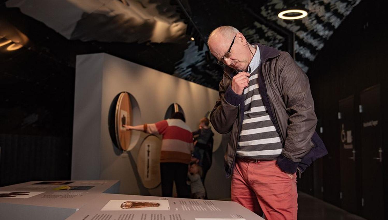 A visitor reading and learning about Viking history at Sagastad.