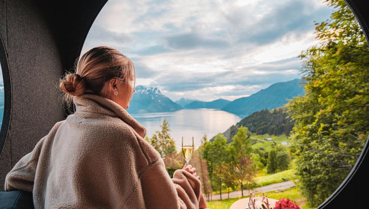 Stunning panoramic view from the Birdbox cabin at Skaara Living on Lotsberg in Nordfjord, surrounded by mountains and fjord landscape.