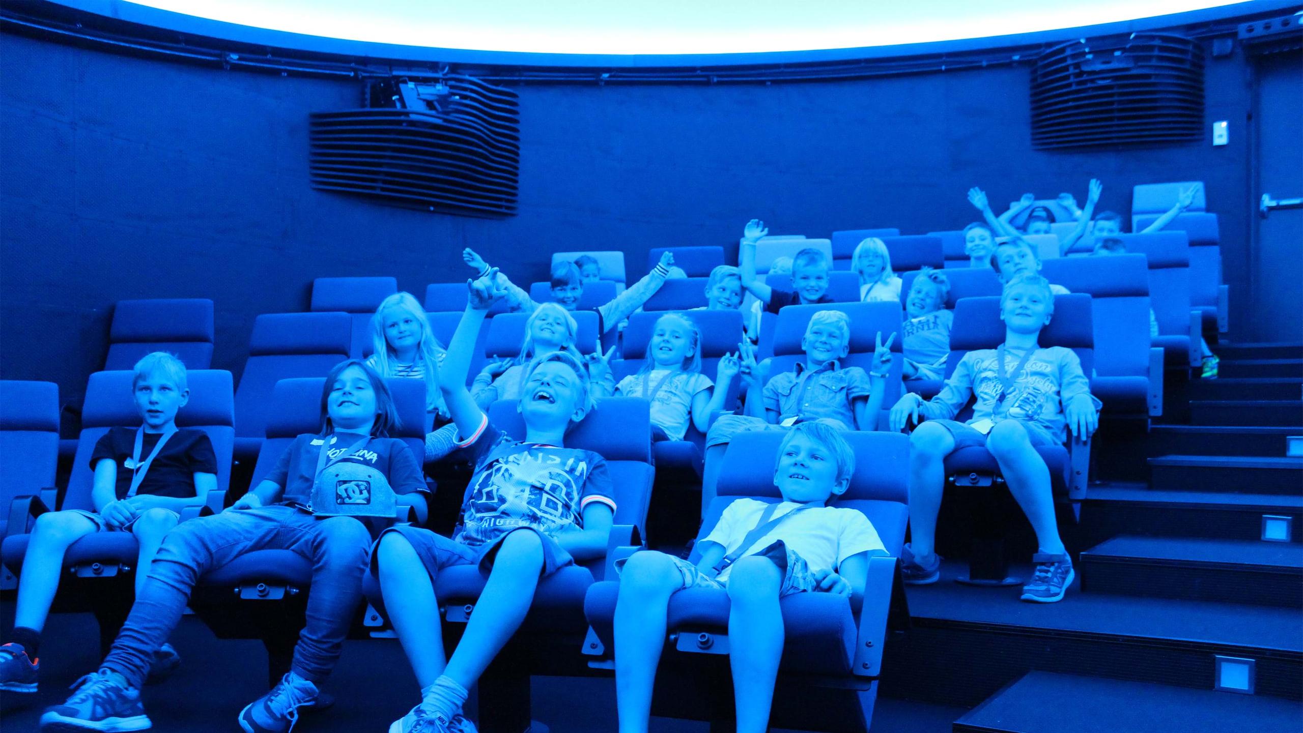 Happy children in the planetarium. Photo.