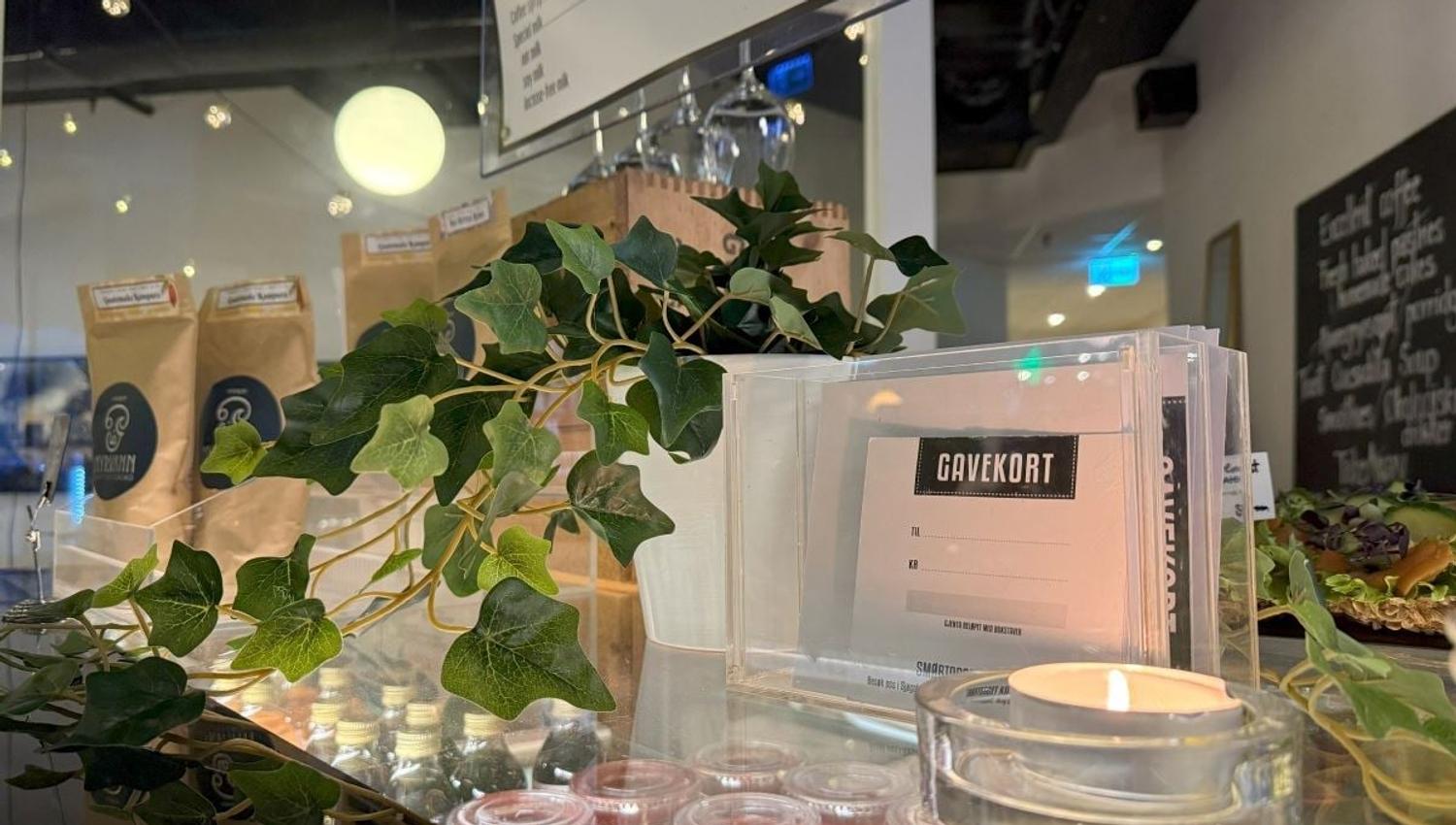 Disken med meny, stearinlys og plante