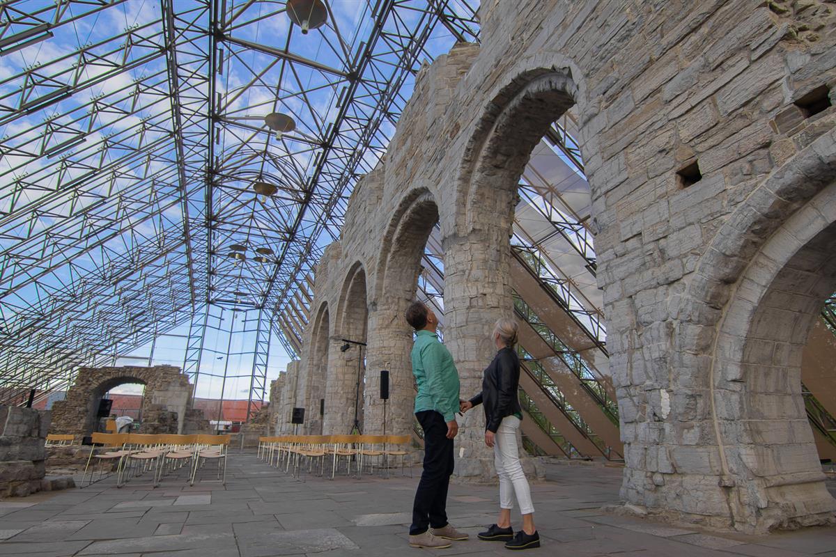 Interiørbilde fra Hamardomen, med høye glassvegger og trekonstruksjoner som omslutter domkirkeruinen. Lyset skaper et luftig og åpent inntrykk.
