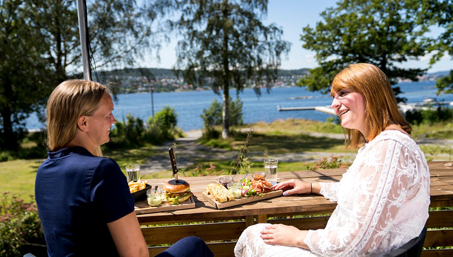 Two girls enjoying food on Bjørkøya in Porsgrunn.