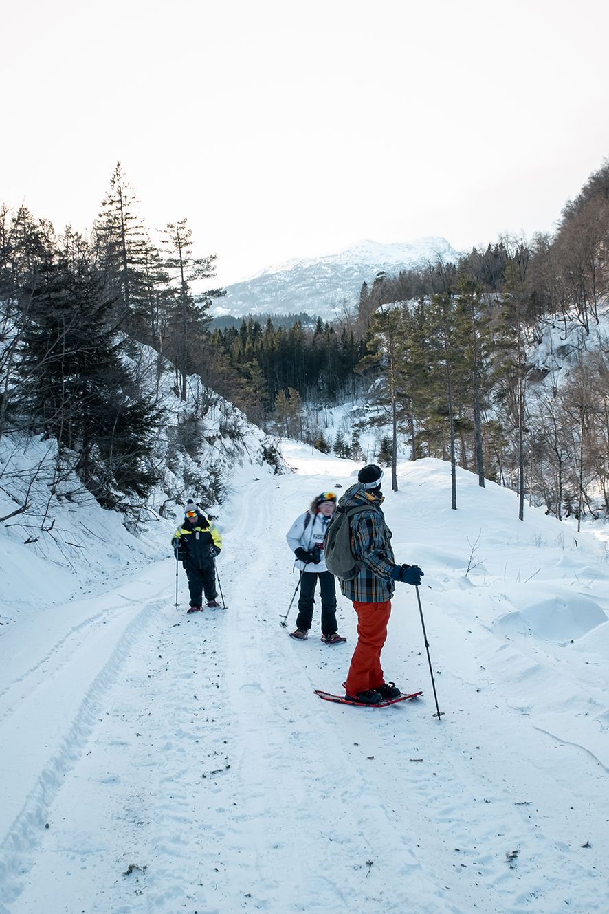 Three snowshoers on a winter trail through the forest in Hardanger.