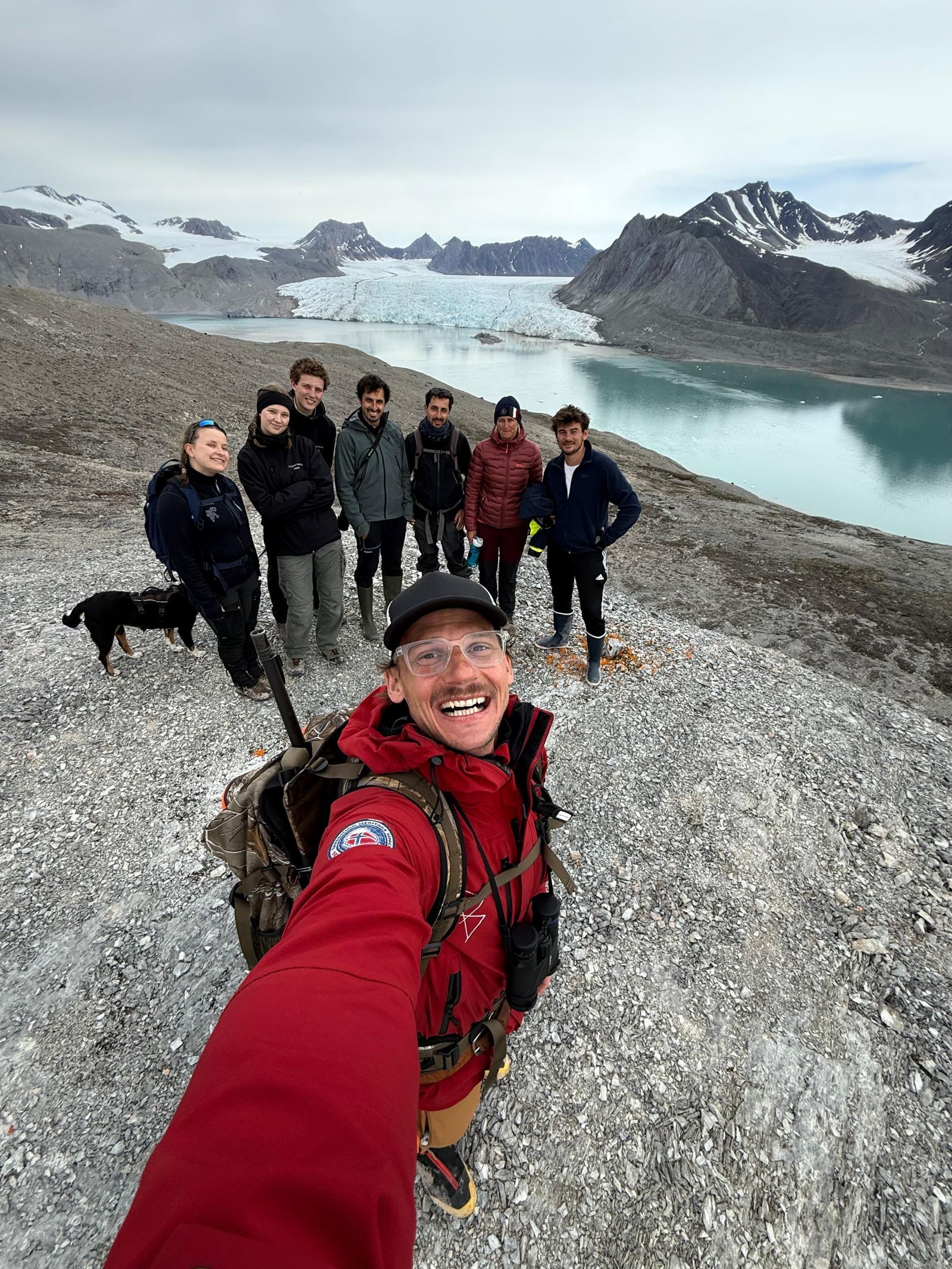 En guide tar selfie med en gruppe på tur med isbre i bakgrunnen