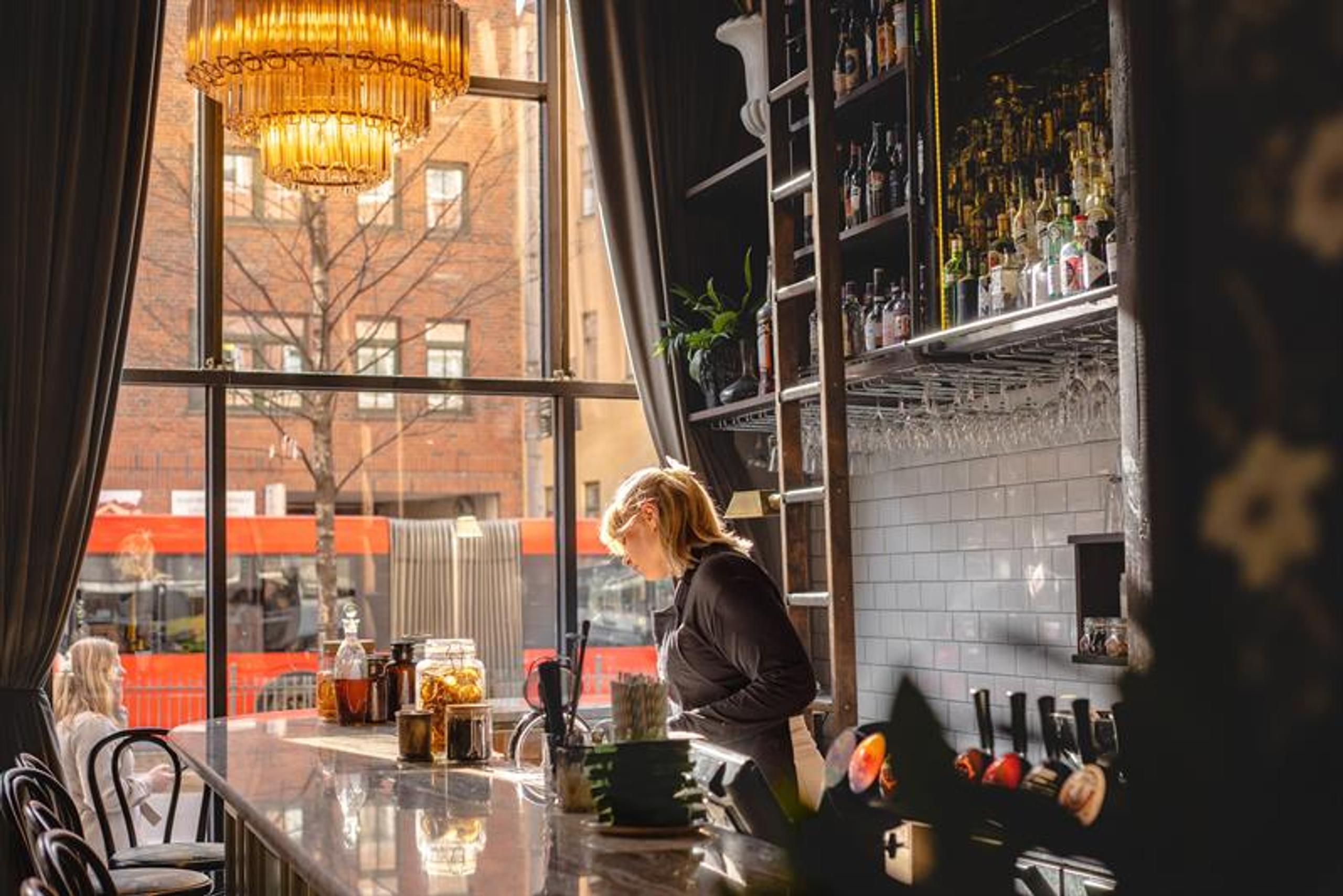 Waitress behind the bar.