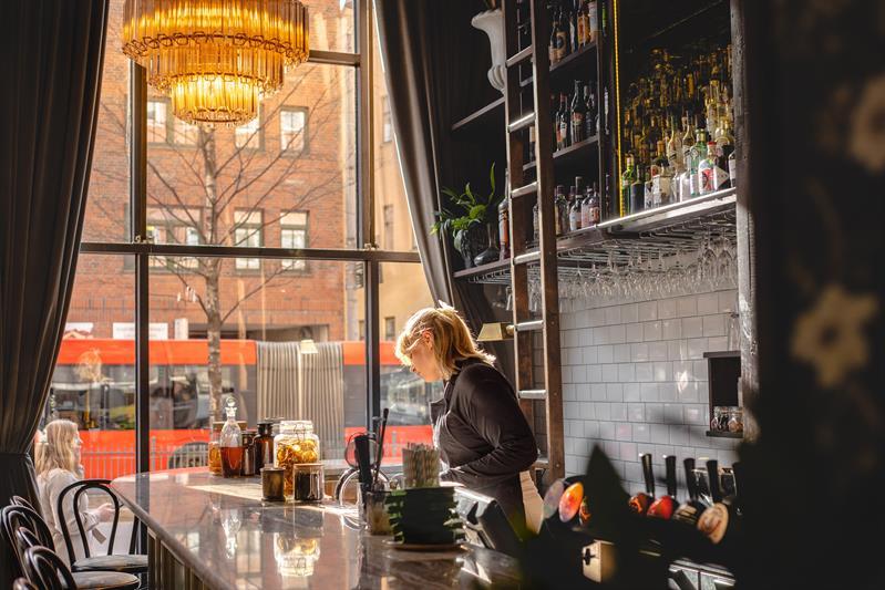 Waitress behind the bar.