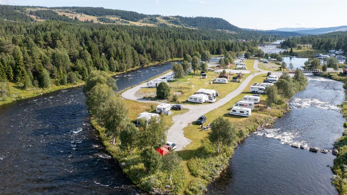 Campingenplassen deler elva i to og ligger fint til omringet av vann.