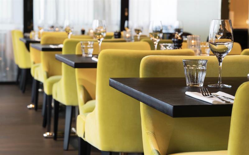 grønne stoler i en restaurant med dekkede bord