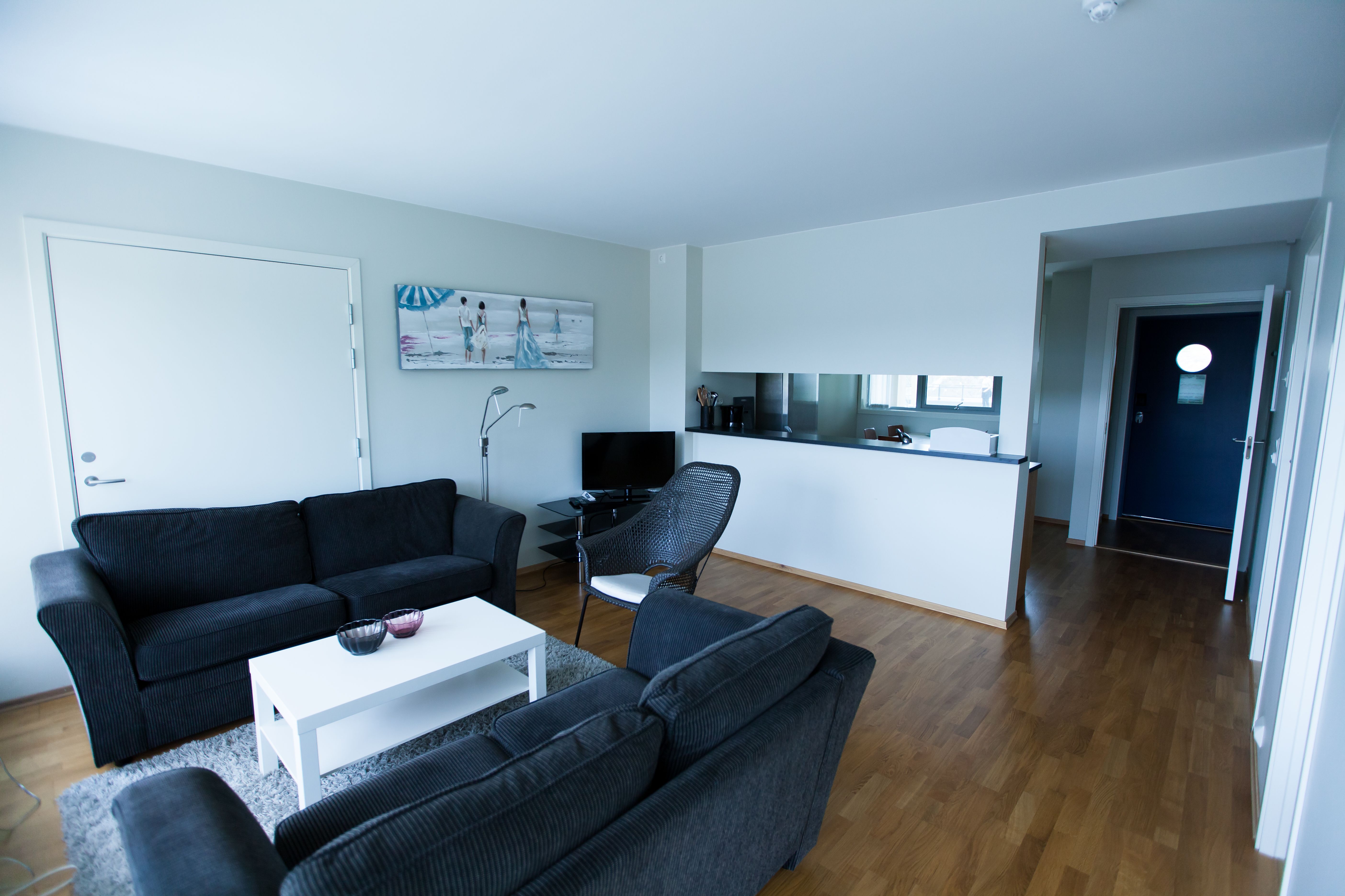 Lindesnes Havhotell - Stua til hotellrommet, et par med svarte toseter sofa.