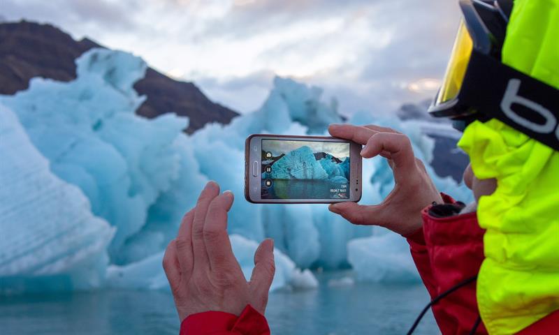 A person taking photos of icebergs