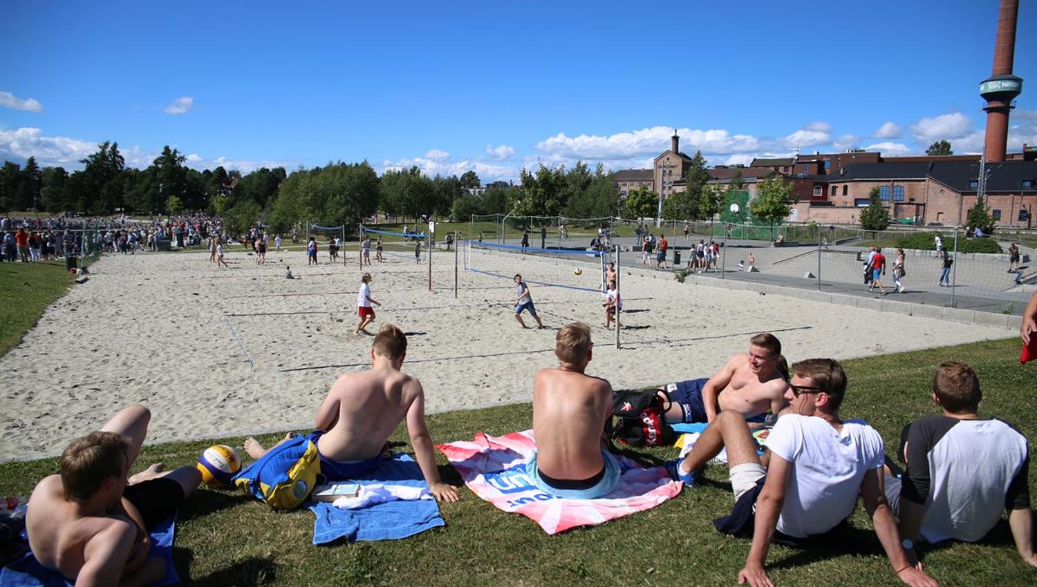 Beach volleyball court and youth sitting beside