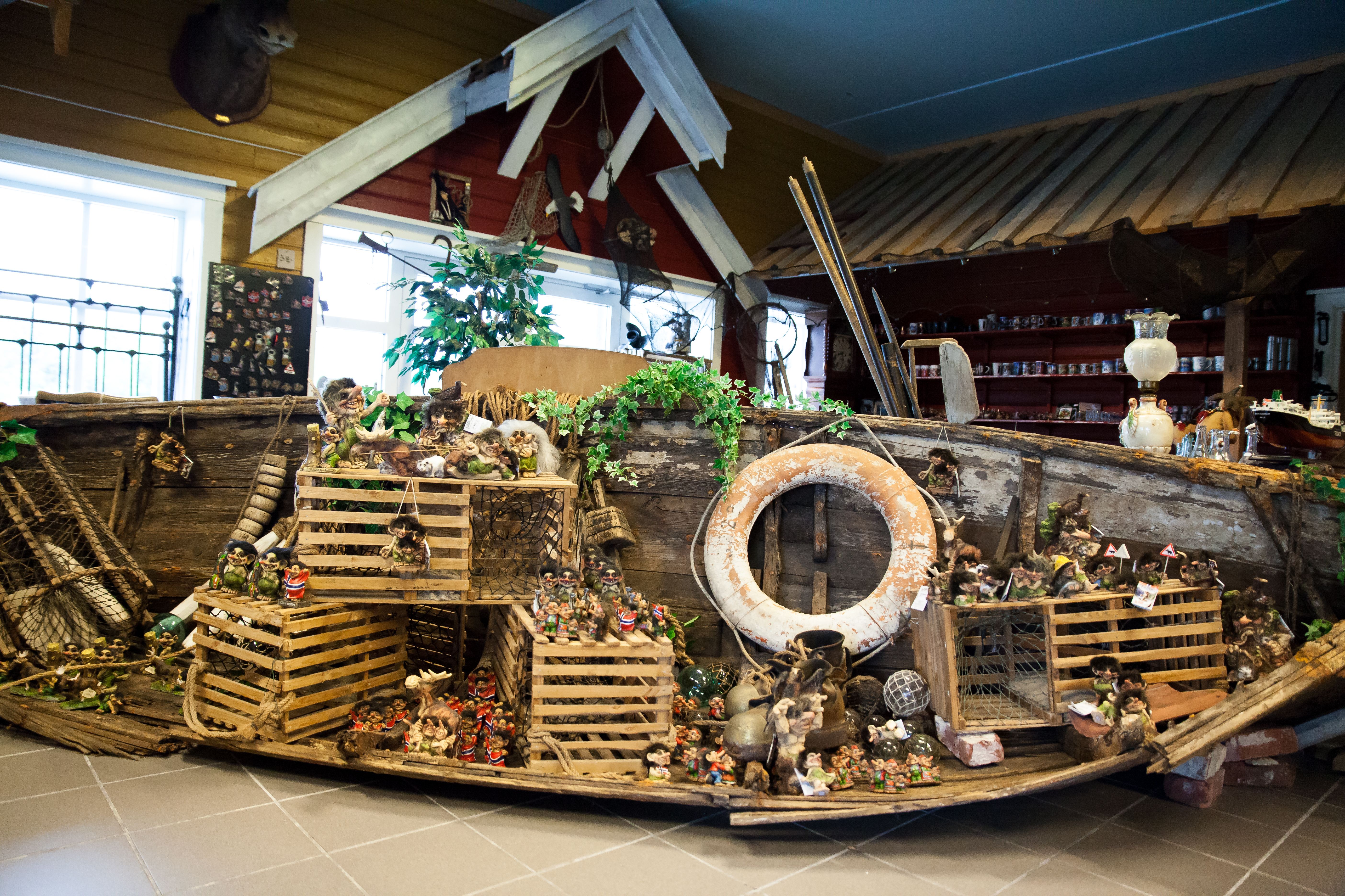 Lindesnes Hytteservice – an old overturned wooden boat decorated with many traditional fishing traps. A large number of small troll figurines are disp
