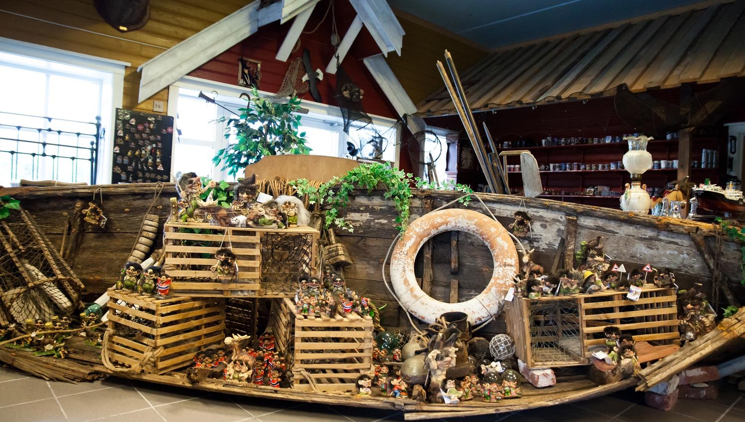 Lindesnes Hytteservice – an old overturned wooden boat decorated with many traditional fishing traps. A large number of small troll figurines are disp