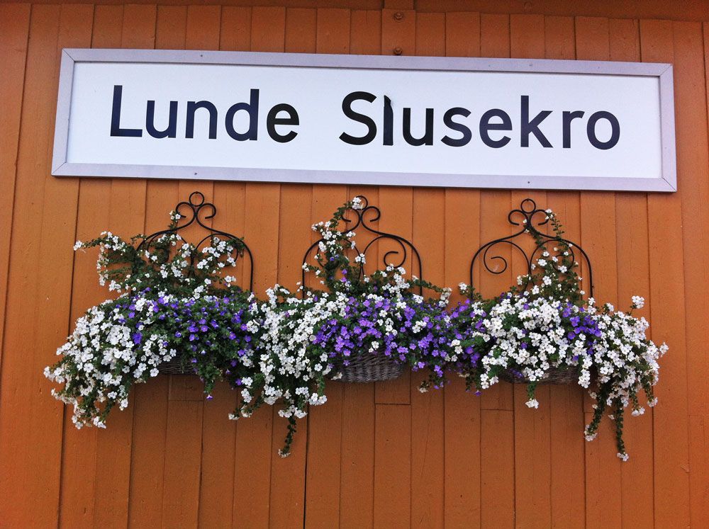 sign for Lunde Slusekro with flowers underneath 