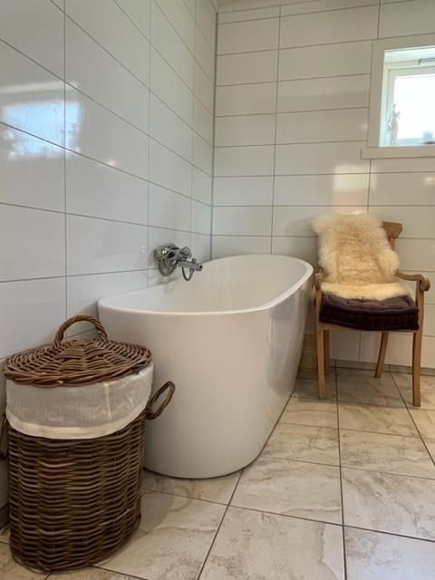 Elegant bathroom with a freestanding bathtub, natural materials, and modern design at Jaastad Gjestetun.
