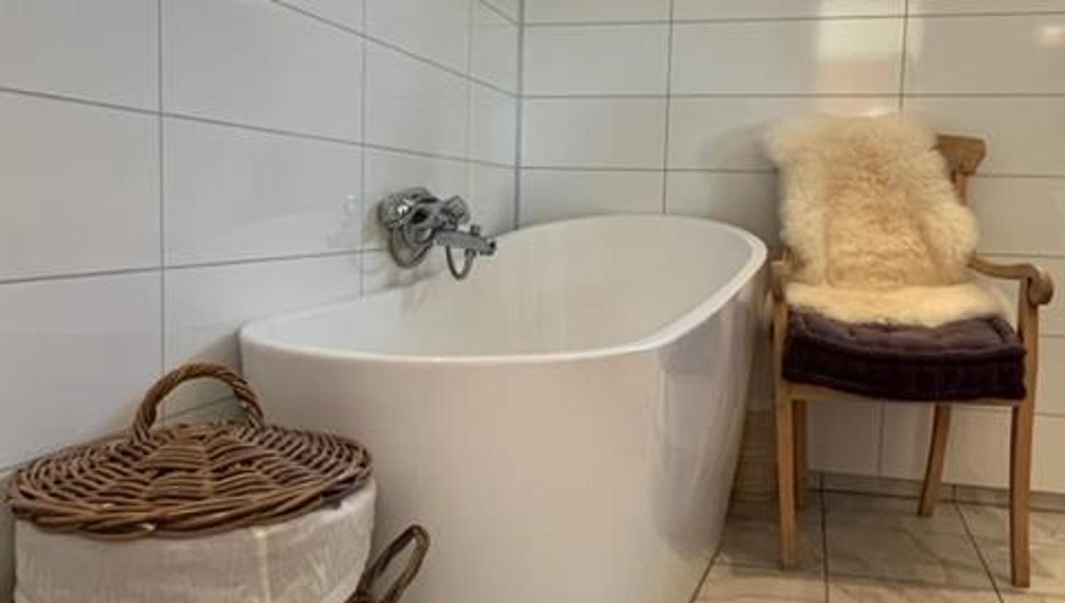Elegant bathroom with a freestanding bathtub, natural materials, and modern design at Jaastad Gjestetun.