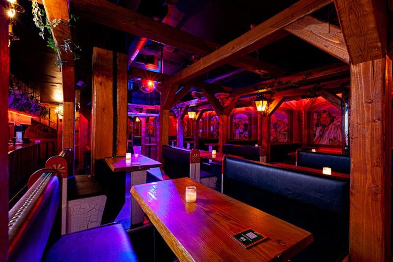 Bar interior with seating booths surrounded by neon lights