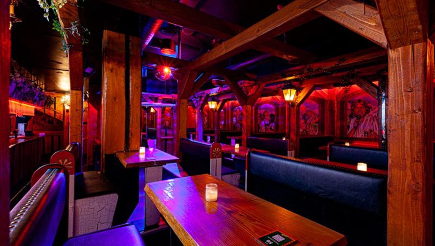 Bar interior with seating booths surrounded by neon lights