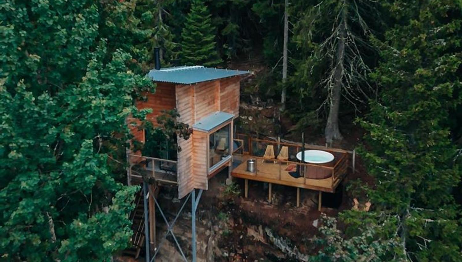 tretopphytte i skogen med en jacuzzi