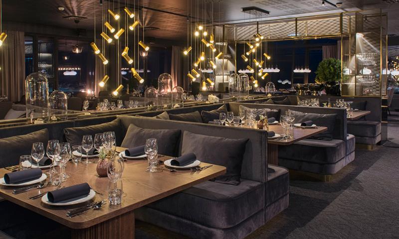 A moody and cozy restaurant dining area with decked tables