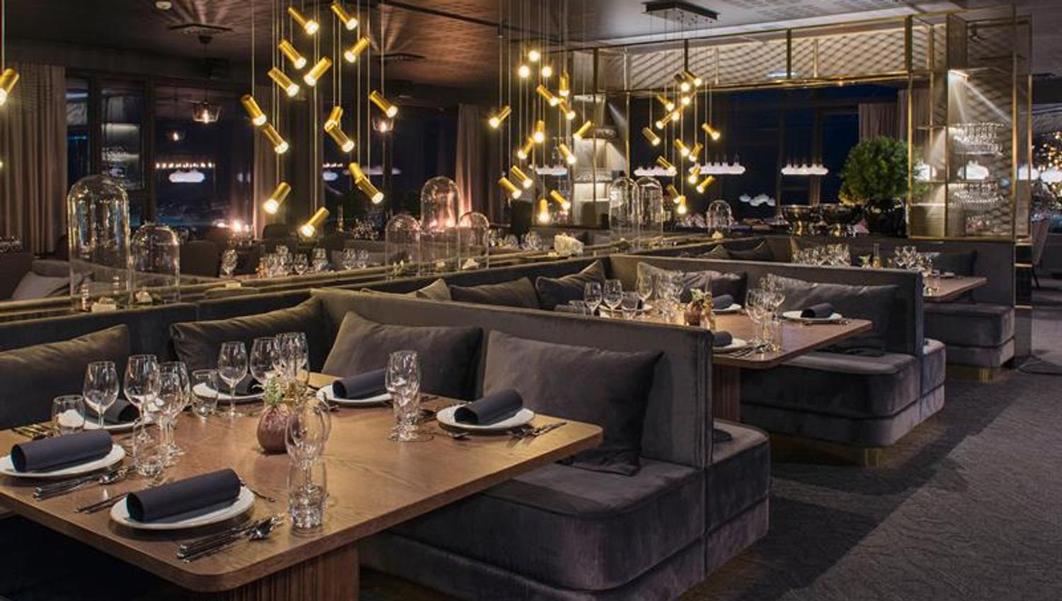 A moody and cozy restaurant dining area with decked tables