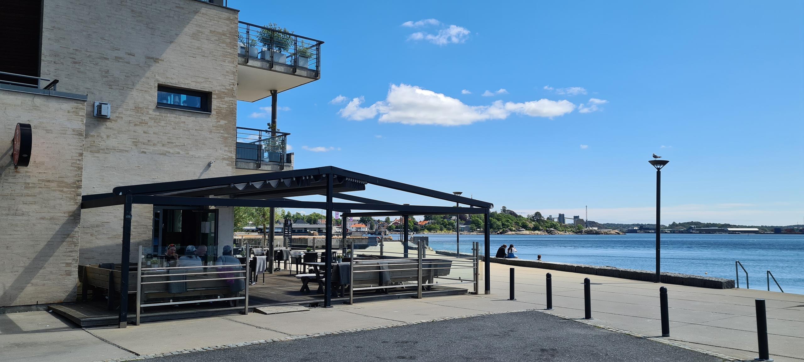 Uteservering ved Peppes Pizza Larvik på Fritzøe Brygge med utsikt mot vannet.