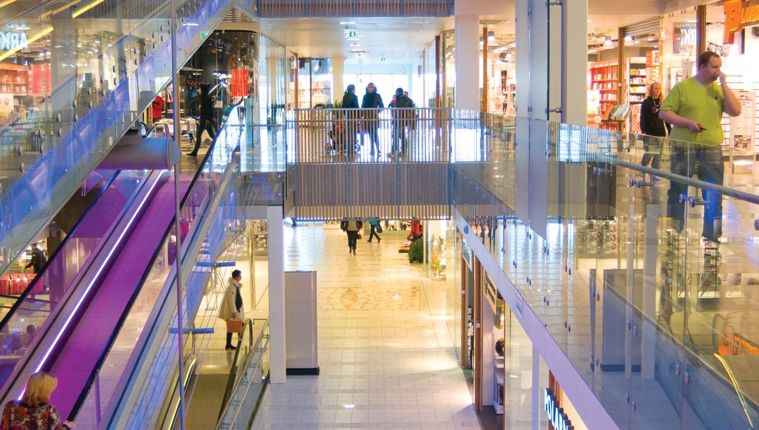 innsiden av kjøpesenteret Jessheim storsenter i duse pastellfarger med lyse glassfasader til butikkene