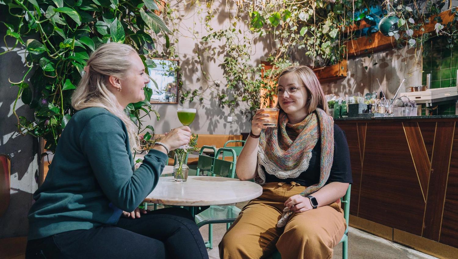 To jenter som drikker cocktails ved baren