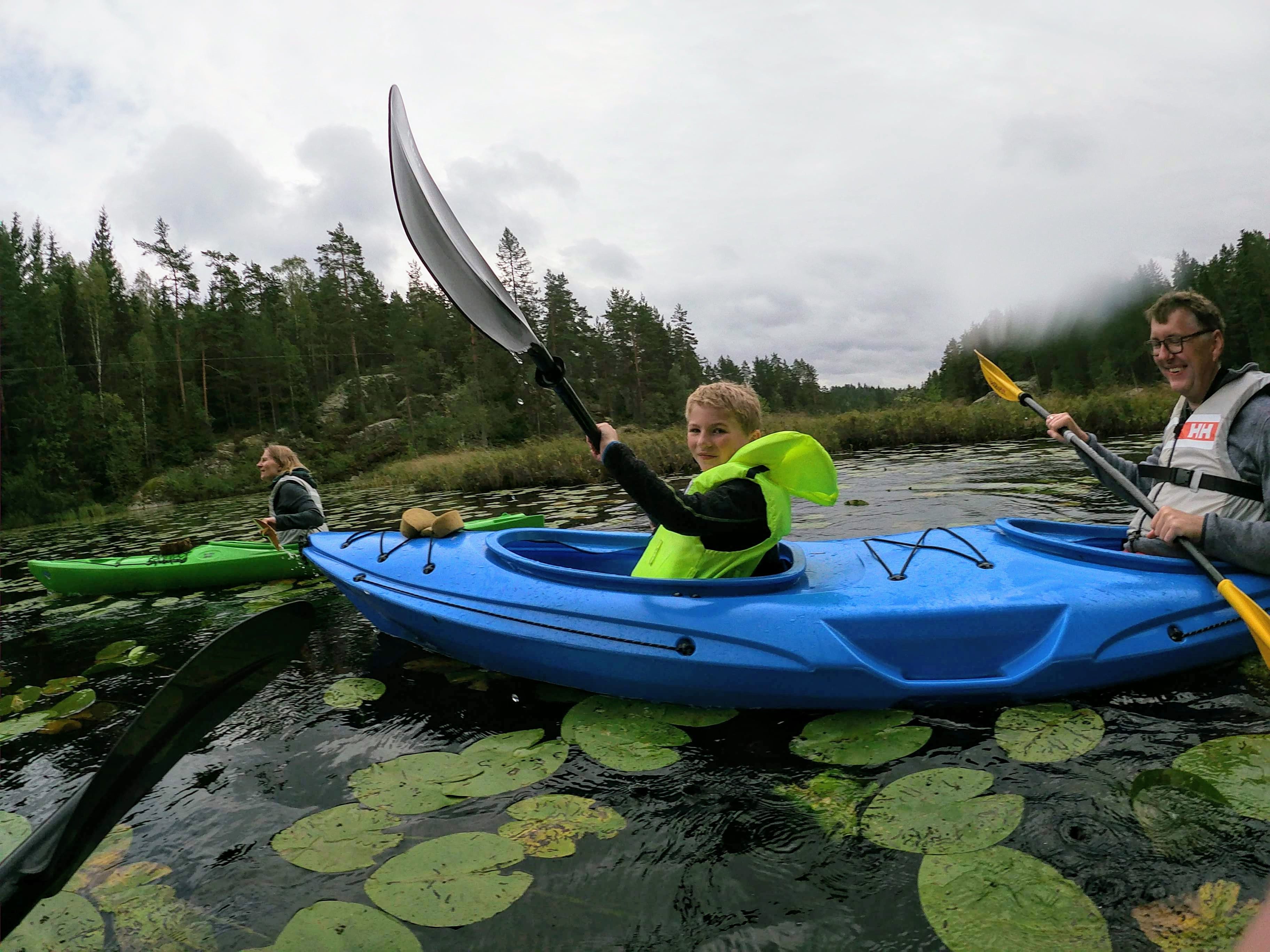 a family with a childe people padling on a lake 