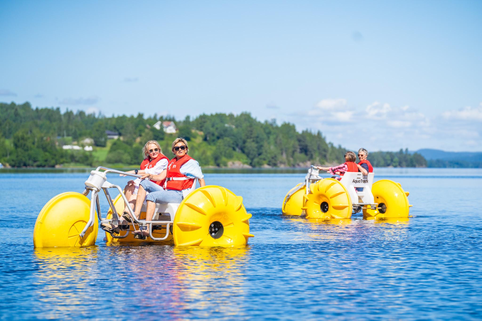 Four persons on pedal bikes on the water