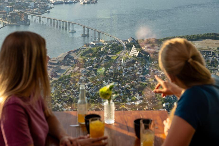 Two females enjoying the view from the Cable Car whilst drinking juice