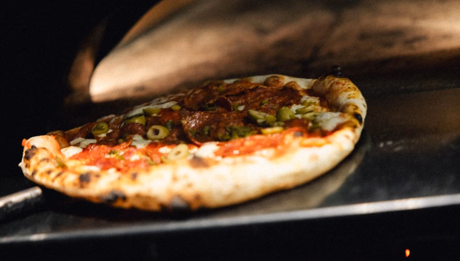 Pizza baking in a wood-fired oven.