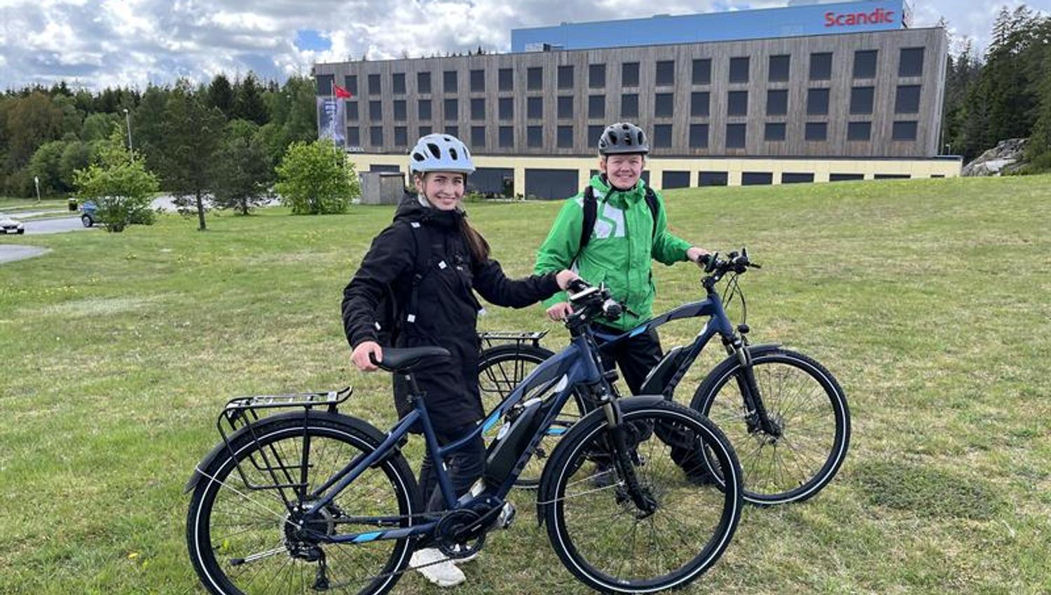 To syklister står på gressplen