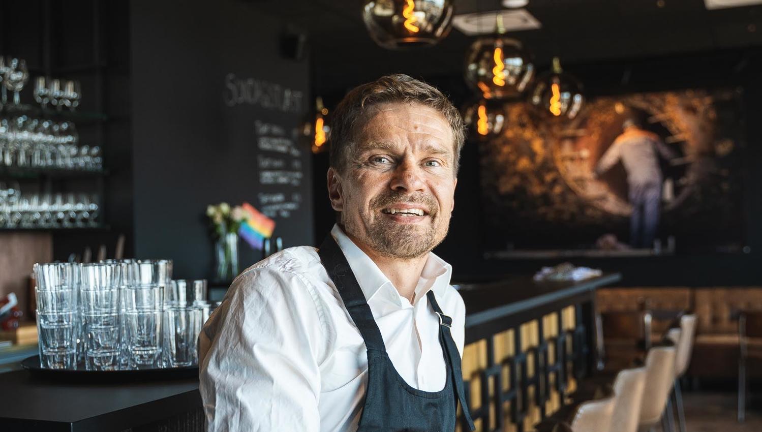 Waiter by the bar smiling