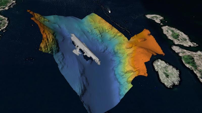A 3D bathymetric map showing the seabed with varying depths, a ship-shaped structure and the surrounding islands.