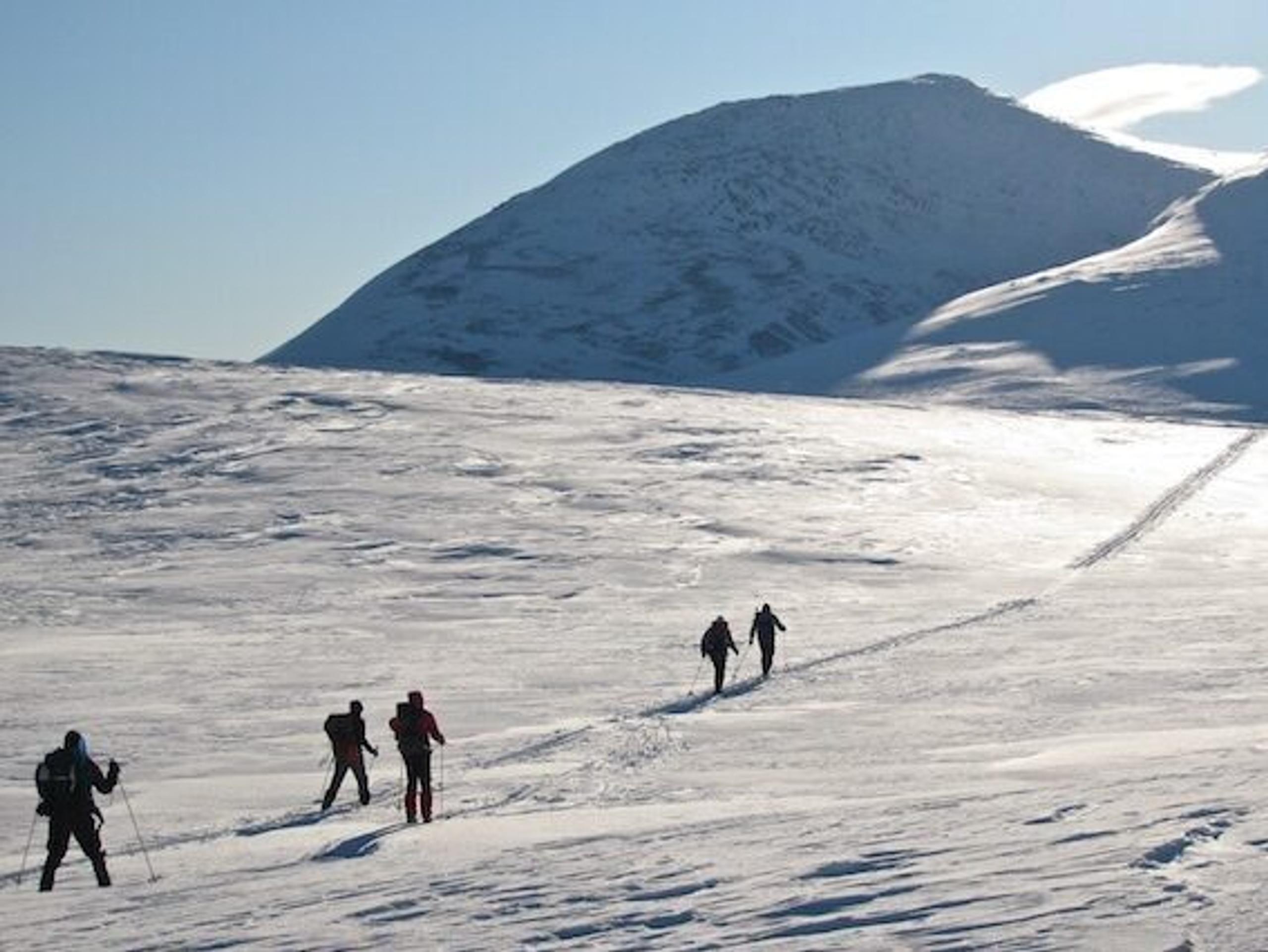 Topptur bilde fra avstand, med mennesker som går oppover i fjellet