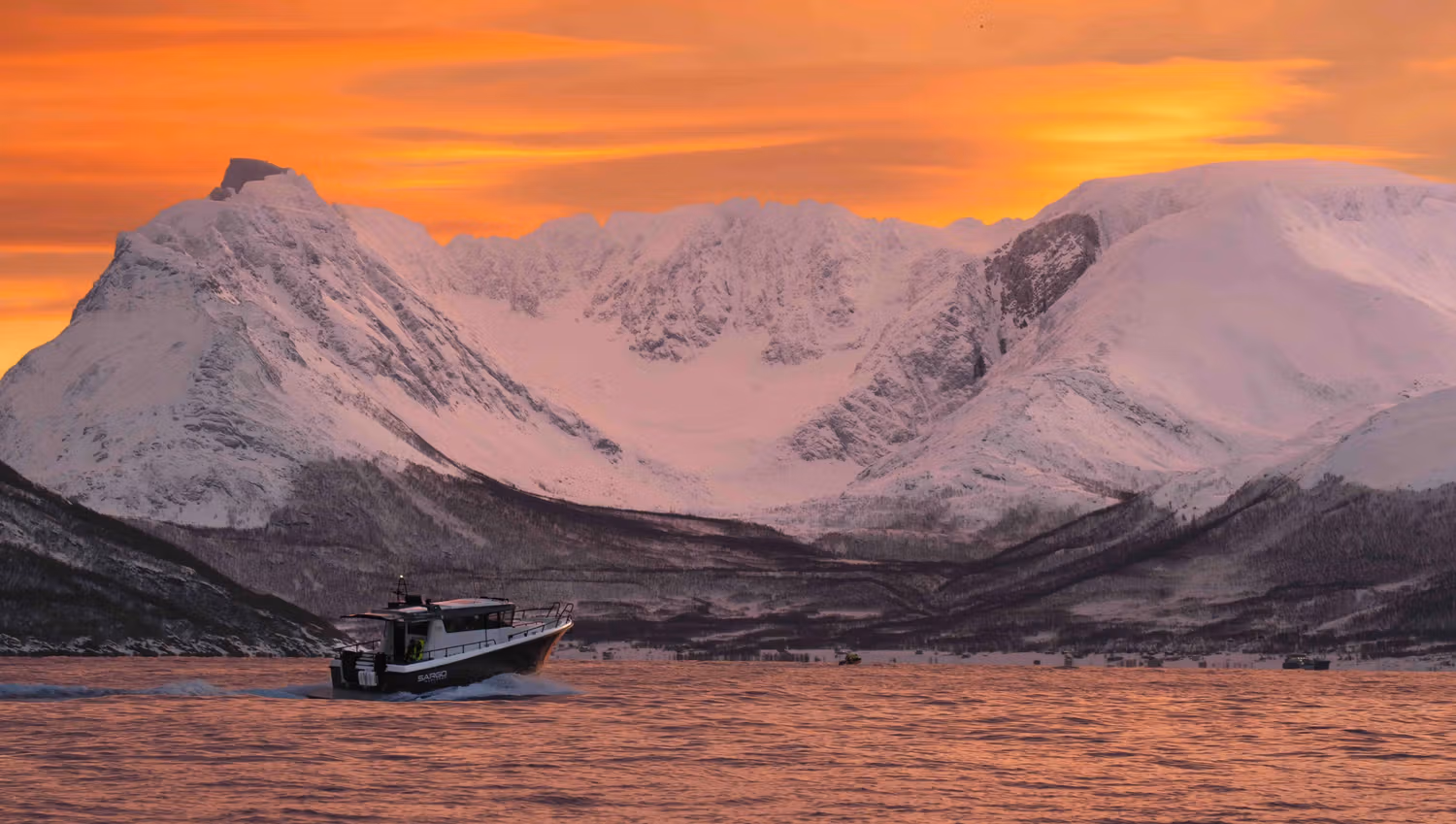 A boat on the fjord in a winter landscape and twilight