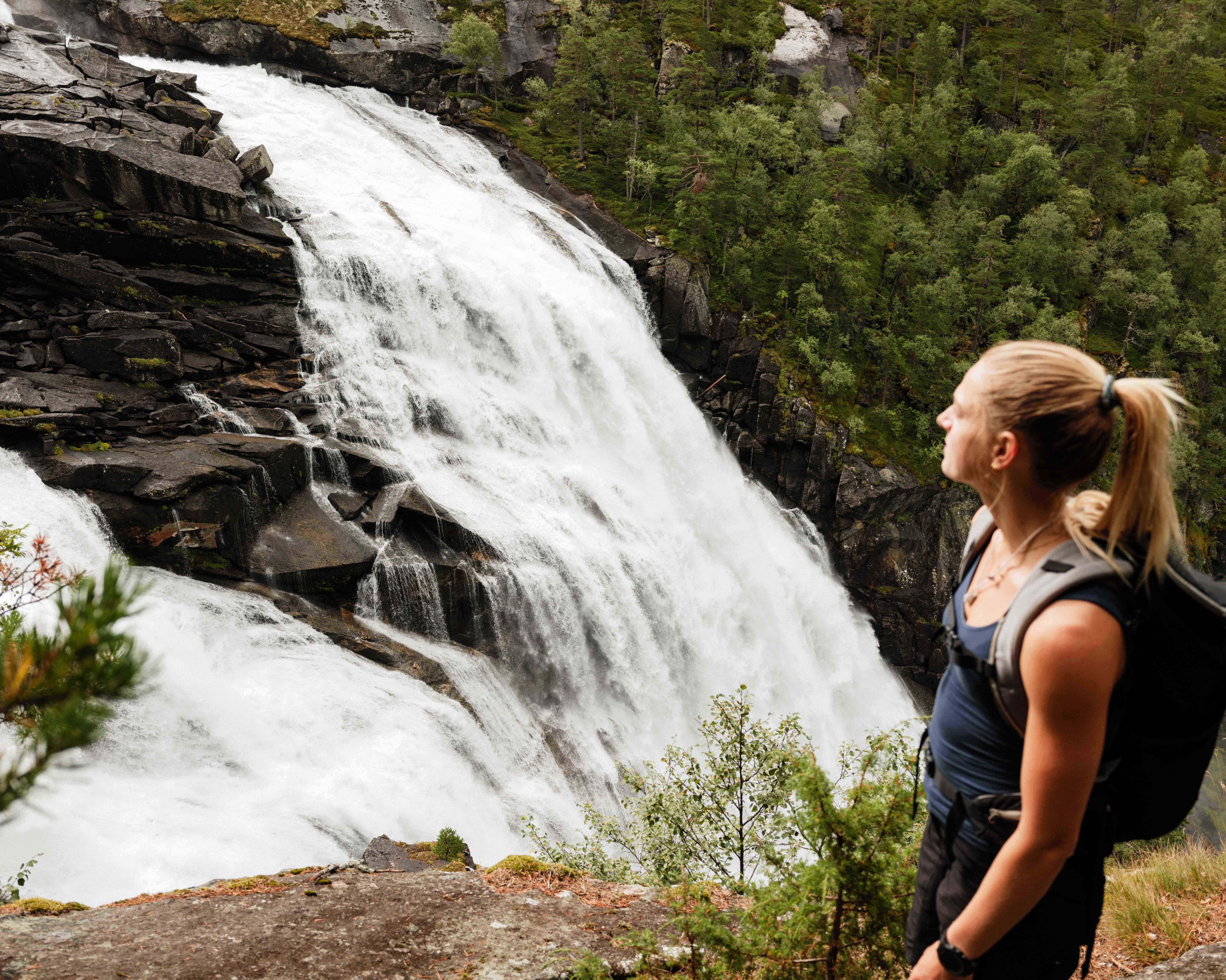 Close-up of a hiker overlooking Nykkjesøyfossen, one of Husedalen’s most stunning waterfalls.