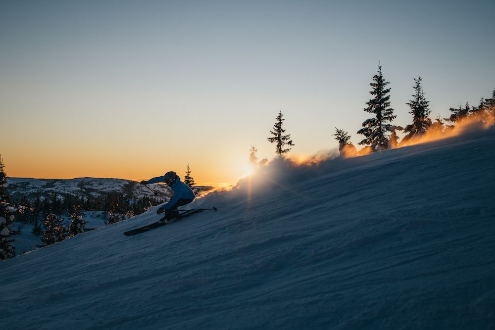 man drives downhill down a hill in the evening sun at Lifjell ski center 