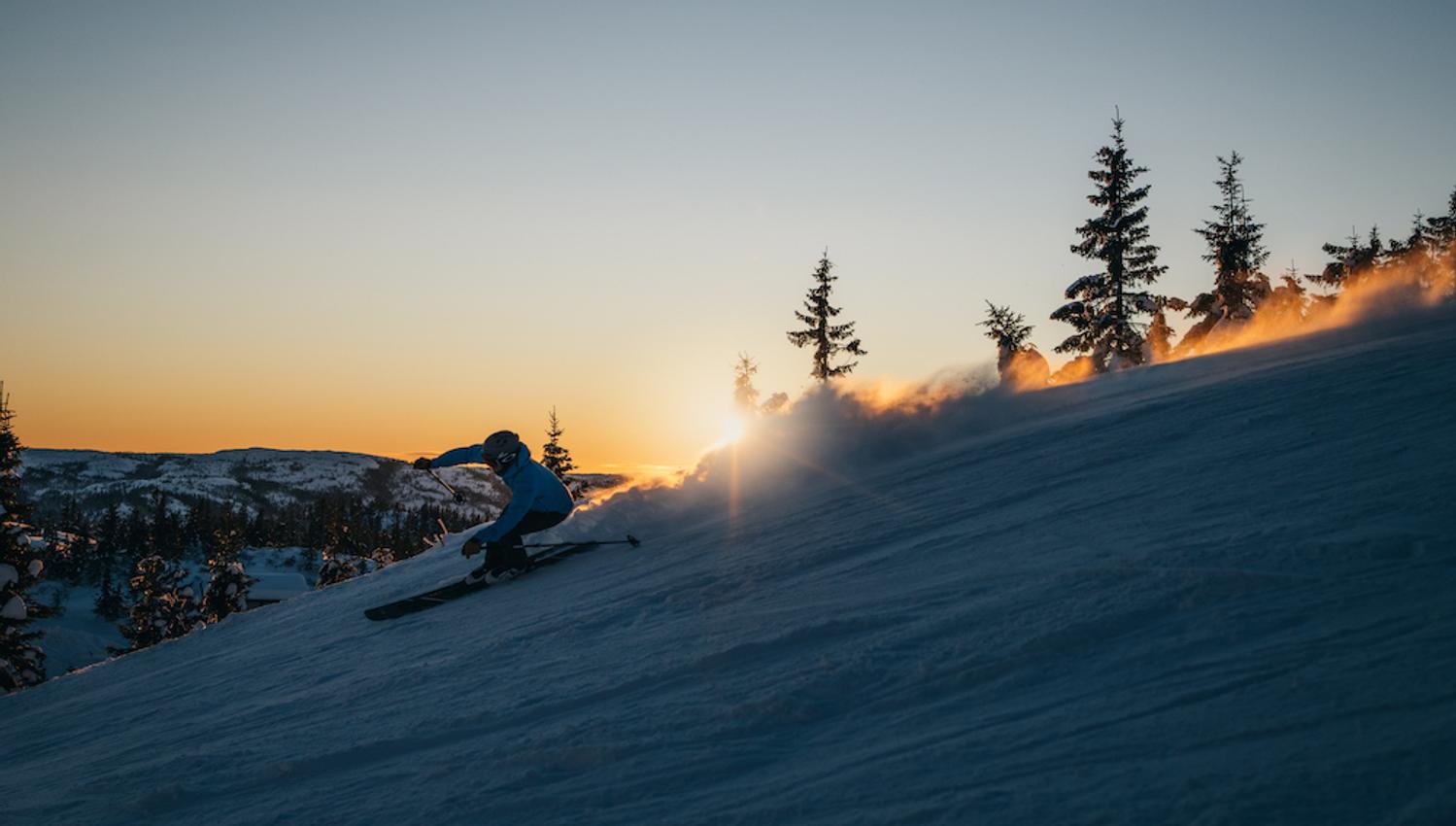 man drives downhill down a hill in the evening sun at Lifjell ski center